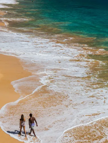 Couple walking down the shores of Mākena Beach on Maui in Hawaiʻi