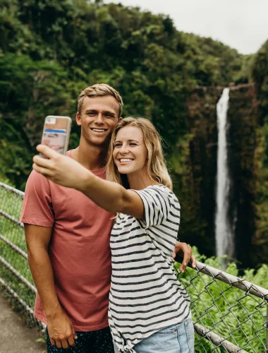Travelers taking a selfie at ʻAkaka Falls State Park on the island of Hawaiʻi