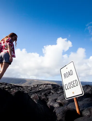 Woman looking at a sign which reads road closed