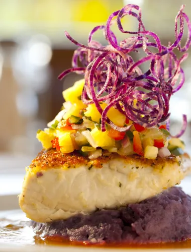Artistically plated fine dining dish featuring fish and vegetables