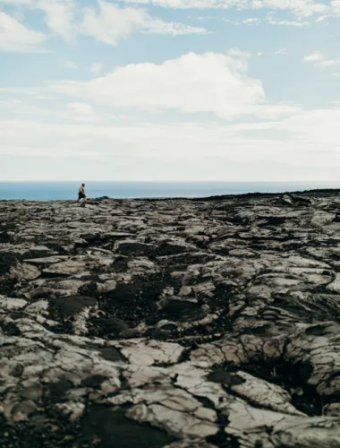 Person in the distance walking on lava fields