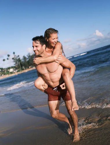 Couple walking along a beach on Kauaʻi in Hawaiʻi