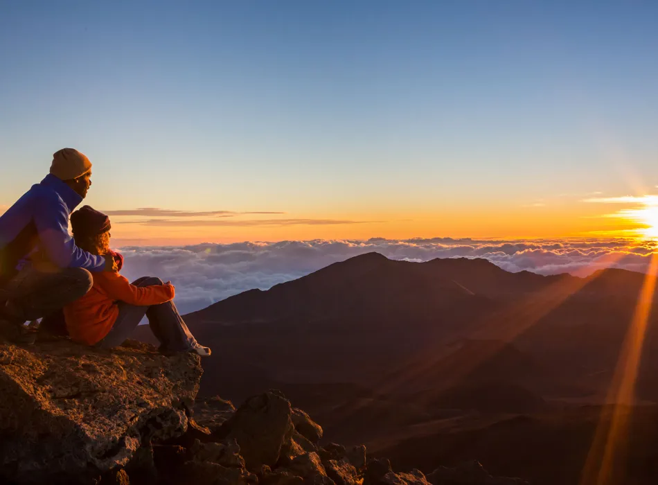 Couple watching the sun rise at Haleakalā National Park on Maui in Hawaiʻi