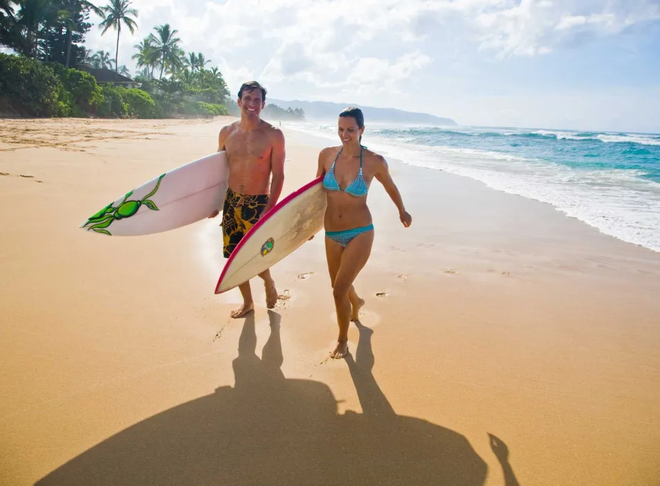 Couple with surfboards at Waimanalo Beach on O'ahu in Hawai'i